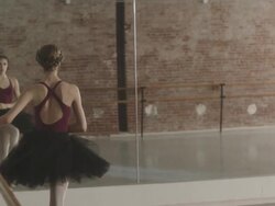 Ballerina stretching at ballet bar in dance studio Stock Footage