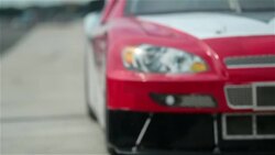 Stock-car driver pulls into pit-road; pit-crew leaps into action, jacks race-car, and removes lug-nuts Stock Footage