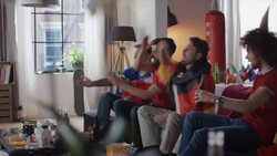 Sport fans sitting on couch watching tv disappointed Stock Footage