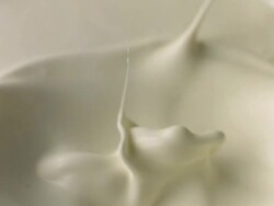 Chocolate splashes into cream Stock Footage