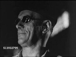 1944: STEEL MILL: INT VS Molten iron overflowing, flowing down canal. MS Male wearing protective eye wear, goggles. VS Flames from furnace, molten steel blocks (called 'blooms'), liquid metal castings. Instructional Video