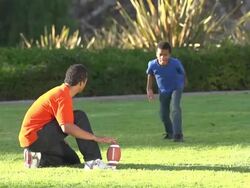A father teaching his sons how to play American football.  Stock Footage