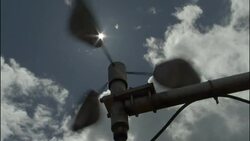A wind gauge operates under a sunny, partly cloudy sky. Stock Footage