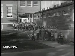 1950: PROVIDING EDUCATION: Children walking out of brick school house & down sidewalk. PULL BACK Children walking, others playing outside school, children leaving school. Instructional Video