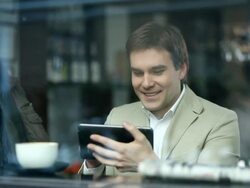 Young man drinking coffee and using tablet Stock Footage