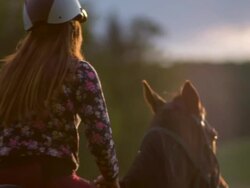 Young woman horseback riding at sunset Stock Footage