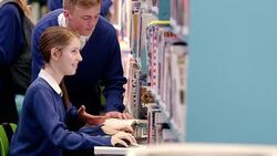 Boy and girl studying at computer in school library Stock Footage