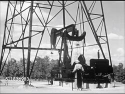 1947: USA OIL INDUSTRY: PUMPING: Male under derrick, sign 'No Smoking, Stanolind Oil & Gas Co... Well No. 10' WS Pump working under derrick. Workers checking separator, walking up steps to catwalk next to tank. CU Checking tank dip stick. Instructional Video