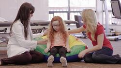 Female occupational therapist working with child patient and her mother Stock Footage