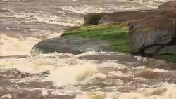 Medium Close Up of water crashing against moss covered rock Stock Footage