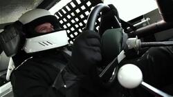 Stock-car driver grips and turns steering wheel Stock Footage