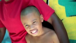 Brazilian father and son smile at camera leaning on graffitied wall in Rio de Janeiro Stock Footage