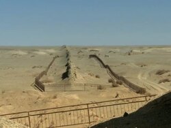 A view of the Great Wall of China where it first began in the desert, with it being protected by fences.  Stock Footage