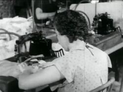 B/W 1934 REAR VIEW woman using sewing machine in WPA garment factory / documentary Stock Footage