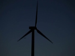 Wind turbine against a blue sky at dusk Stock Footage