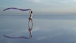 Young ballerina dancing on the salt lake with color tulle Stock Footage