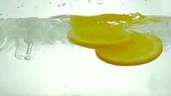 Orange slices drop in the ice water. Close up. Slow motion. Stock Footage