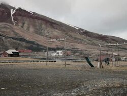 Ruined kids playground with seagulls flying around in Pyramiden, a Soviet Ghost Town on the archipelago of Svalbard Stock Footage