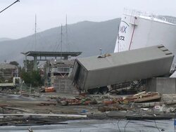 Destruction caused by tsunami after magnitude 9 Tohoku earthquake, north east Japan, March 2011. Large truck lies on top of wall next to large oil storage tanks in Ishinomaki City port, Miyagi Prefecture Stock Footage