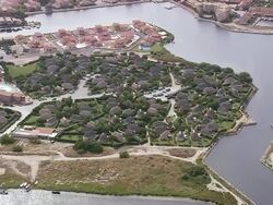 MS AERIAL Shot of Holiday complex behind Port Barcares (for red roofs) / Languedoc Roussillon, France Stock Footage