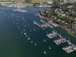 Aerial wide shot pan coastline and boats in Cork Harbour / Cork, Ireland Stock Footage