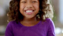 Cute young girl holds plate of Christmas cookies, giggles and smiles at camera Stock Footage