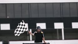 Stock car race official waves checkered flag Stock Footage