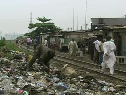 WS View of burning plastic with people working / Lagos, Nigeria Stock Footage