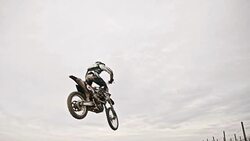 SLO MO Dirt biker jumping over dirt ramp Stock Footage