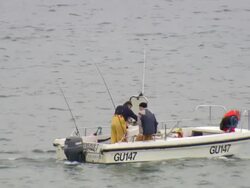WS View of men fishing with boat floating in Sea Stock Footage