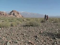 Couple mountain biking towards camera in rocky terrain Stock Footage