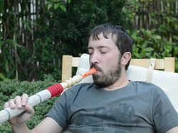 Young man smoking water pipe and drinking tea Stock Footage