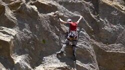 A young man rock climbing on a mountain.  - Slow Motion Stock Footage