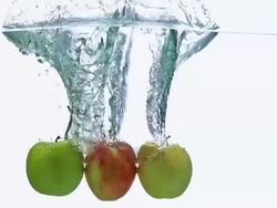 CU SLO MO Shot of Apples, malus domestica, Fruits entering Water against White Background / Calvados, Normandy, France Stock Footage
