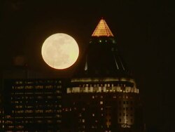 The full moon rises behind two skyscrapers in Manhattan.   Stock Footage