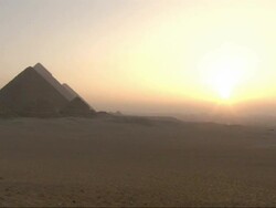 Wide Shot, static - A golden-hour sky silhouettes the Pyramids of Giza in Egypt Stock Footage