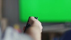 Guys sitting on couch watching tv and switching Stock Footage