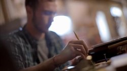 Young man studies laptop screen and taps pencil on desk Stock Footage