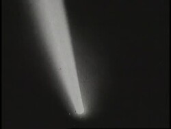 A searchlight moves through the darkness at night. News Clip