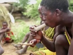 hadzabe men sitting and smoking by the fire  Stock Footage