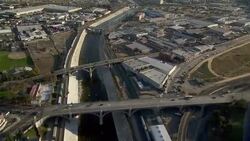 Tracking shot over the Los Angeles River where bridges allow traffic to cross into Downtown LA. Stock Footage