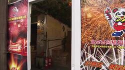 An employee shuts a door to a fireworks store covered in posters. Stock Footage