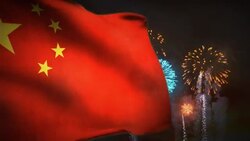 A Communist China flag waves in the wind as fireworks explode behind it. Stock Footage