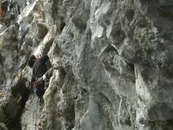 A Japanese rock climber working his way up a rock face Stock Footage