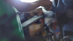 Woman hands credit card to cashier who swipes it through tablet card reader Stock Footage