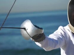 A man and woman fencing on the beach. - Slow Motion Stock Footage