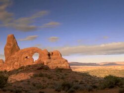Wide shot of Turret Arch and desert landscape with bright blue skies and interesting clouds Stock Footage