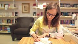 Young business woman writing notes in a bookstore. Stock Footage