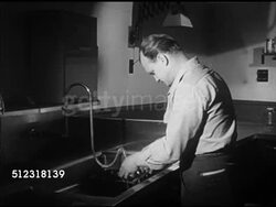 1953: PALOMAR OBSERVATORY: Unidentified scientist washing developer chemicals off photo plate, holding a plate up to lightbox. PHOTO: Saturn.     Astrophotography, Caltech, California Institute of Technology, Instructional Video