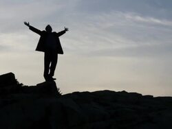 WS Man standing on rocks raising arms / Portland, ME, United States Stock Footage